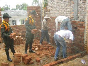 El patrullero Marlon Escobar, el subintendente Mauricio Gutiérrez y James Peteví, obrero, adelantan la preparación del concreto que se usará en la edificación de las paredes.